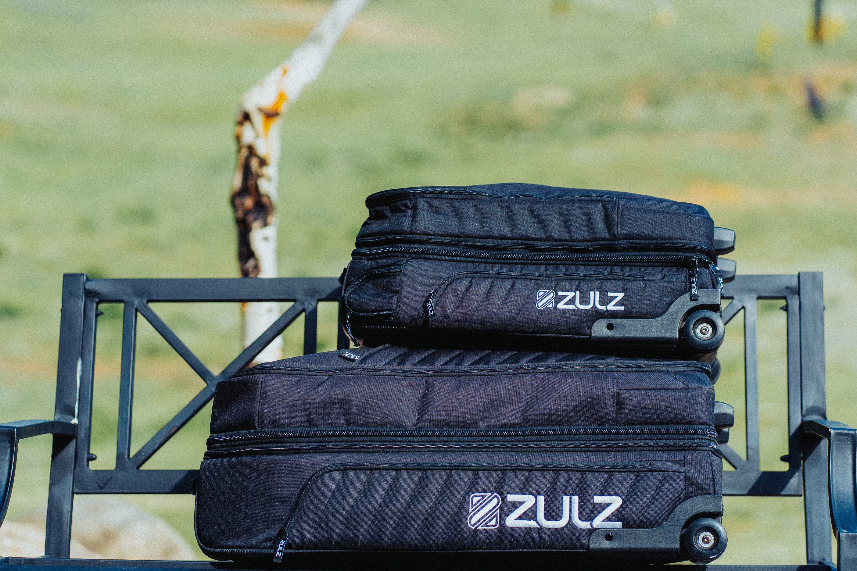 A carry-on bag laying on top of a check size bag
