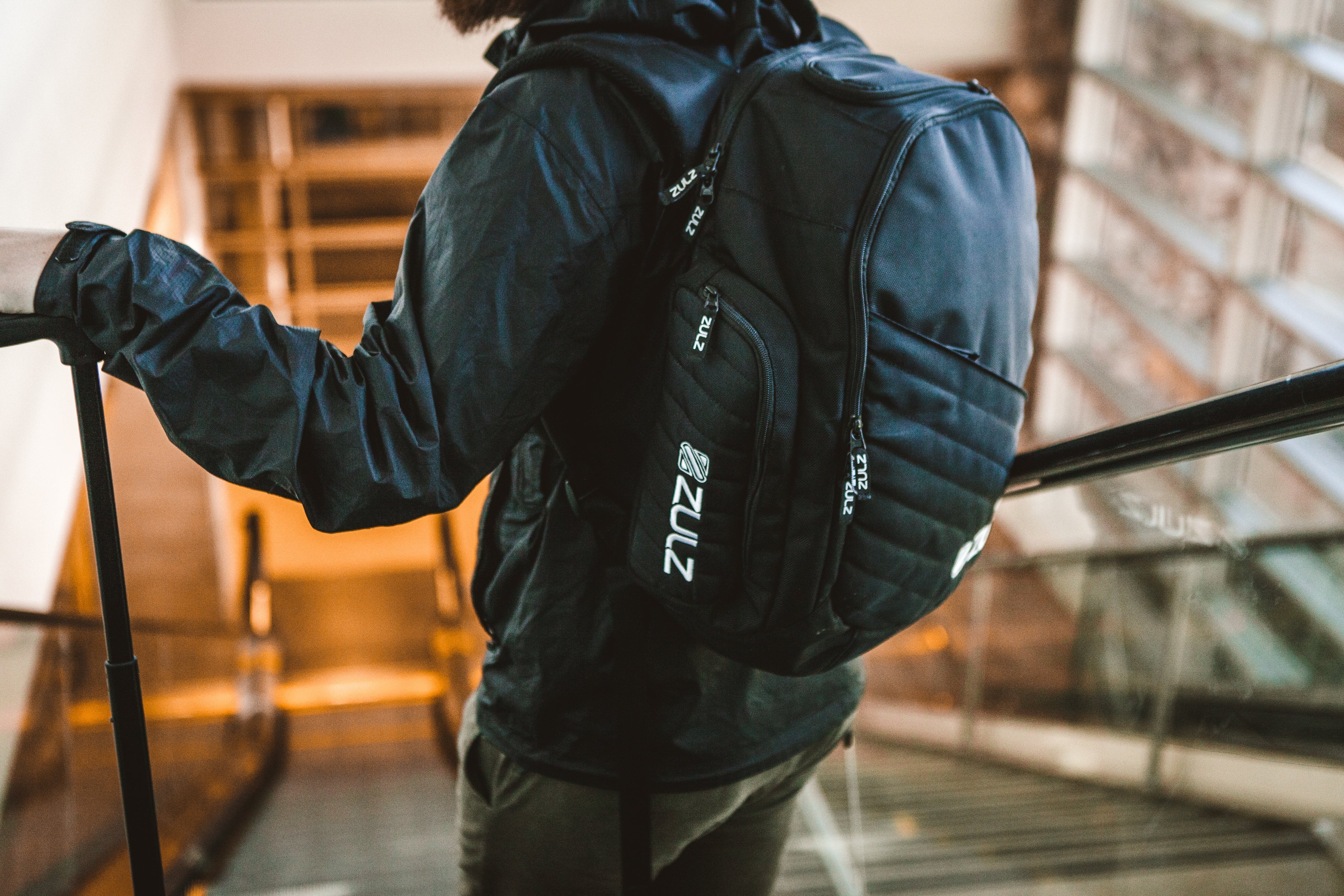 A traveler riding down an escalator with backpack in view