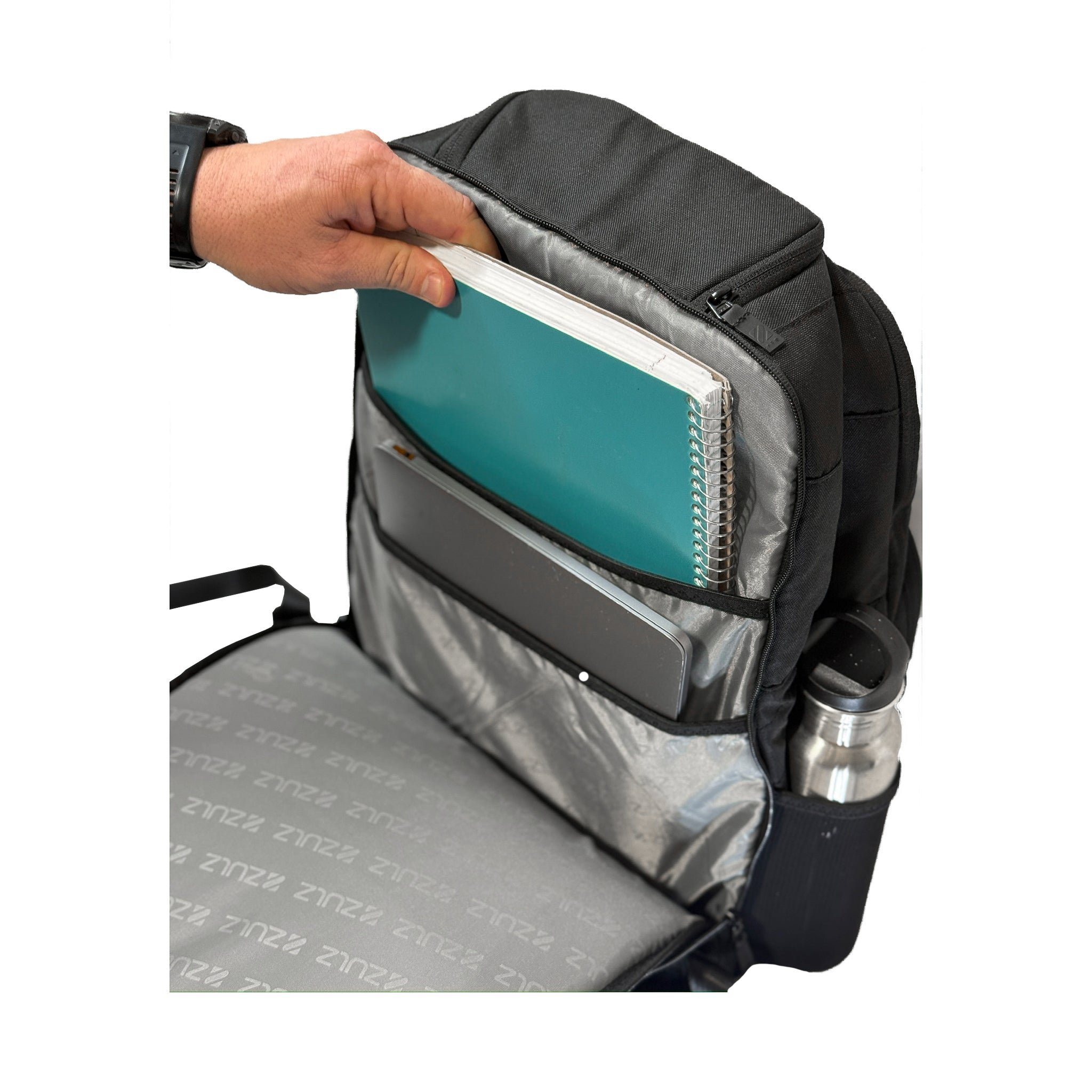 Person placing a teal laptop into a black backpack with a white background
